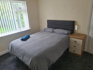 Un dormitorio con una cama con una almohada azul. en L & J Escapes - 8 Bedrooms suitable for Contractors and Families- Private parking available for 6 vehicles en Coseley