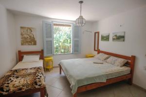 a bedroom with two beds and a window at Tranquilidade e Conforto em Guaramiranga in Guaramiranga
