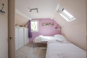 1 dormitorio con 2 camas y pared púrpura en La Maison du Pêcheur, en Étretat