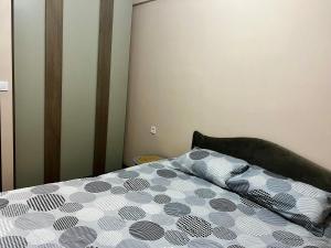 a bedroom with a bed with a black and white comforter at Juliya Apartment in Kavadarci