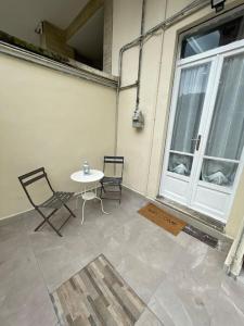 d'une terrasse avec une table, des chaises et une fenêtre. dans l'établissement Loft Alby 10 ristrutturato nuovo, à Turin