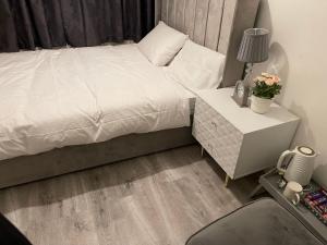 a bedroom with a white bed and a night stand with a nightstand at Divine Room in London