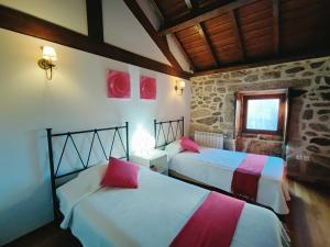 a bedroom with two beds with red and white sheets at Casa das Falagueiras in Castro Laboreiro