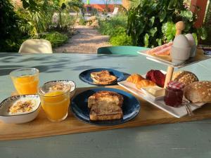 a table with plates of breakfast foods and drinks on it at Tropical Cabins Curaçao in Dorp Sint Michiel