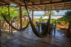 a porch with a hammock and a table on the beach at The Sea Garden House in Olón
