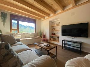 a living room with two couches and a flat screen tv at El mirador de Mati in Torrecilla en Cameros