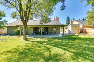 a house with a tree in the yard at Charming Redding Home with Furnished Patio! in Redding