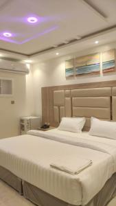 1 Schlafzimmer mit 2 Betten und einem lila Licht in der Unterkunft ديار الفارس in Yanbu