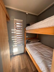 1 dormitorio con 2 literas y ventana en 2 Hometainer Natales, en Puerto Natales