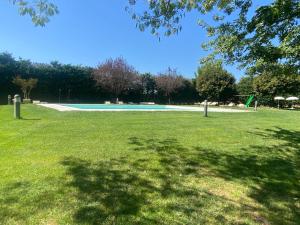 a green park with a swimming pool in the grass at La Locanda dei Golosi in Bosco
