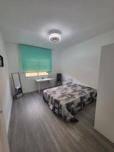 1 dormitorio con cama y pantalla verde en Estilo Urbano San Gines, en Cartagena