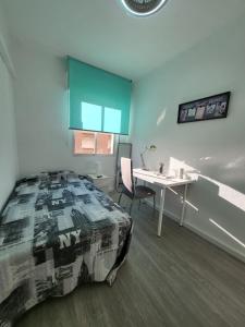 1 dormitorio con cama, escritorio y mesa en Estilo Urbano San Gines, en Cartagena