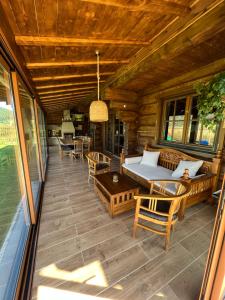 a porch of a log cabin with a bed and chairs at Cabin House Čičmany- Relaxačné zariadenie s ubytovaním in Čičmany