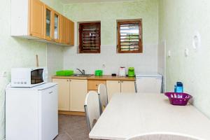 a kitchen with a table and a white refrigerator at House Ivana Tribunj in Tribunj