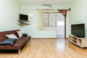 a living room with a brown couch and a television at House Ivana Tribunj in Tribunj