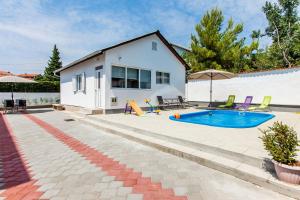 a backyard with a swimming pool and a house at House Ivana Tribunj in Tribunj