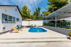 a backyard with a swimming pool and a playground at House Ivana Tribunj in Tribunj
