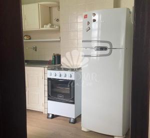 een witte koelkast in een keuken met een fornuis bij Apartamento Cotê D'Azur à beira-mar. in Maceió