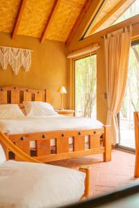 a bedroom with two beds and a large window at Refugios La Frontera in Pisco Elqui