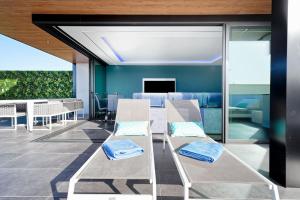 a living room with a couch and a table and chairs at Blue Star Meloneras Villa in San Bartolomé de Tirajana