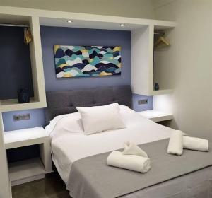a bedroom with two beds and a painting on the wall at Farisma - Bright and central apt in Kalamata in Kalamata +8 photos