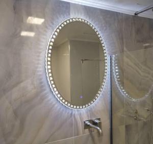 a bathroom with a mirror and a shower at Farisma - Bright and central apt in Kalamata in Kalamata