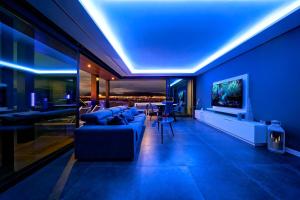 a blue living room with a couch and a tv at Blue Star Meloneras Villa in San Bartolomé de Tirajana
