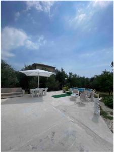 a patio with tables and a white umbrella at Casa vacanza “oasi” in Salerno