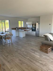 cocina y sala de estar con mesa y sofá en La Villa des Vergers en Coulounieix-Chamiers