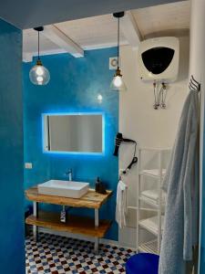 baño con lavabo blanco y pared azul en Casa Vacanze Penelope, en Pizzo