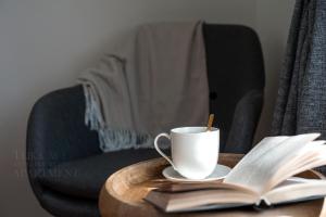 une tasse de café et un livre ouvert sur une table dans l'établissement Teika No 1 Apartment in a quiet green area, self check-in, à Riga