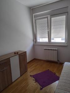 a living room with a couch and two windows at Apartman in Mali Mokri Lug