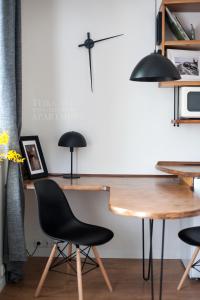 a desk with a black chair and a table at Teika No 1 Apartment in a quiet green area, self check-in in Rīga