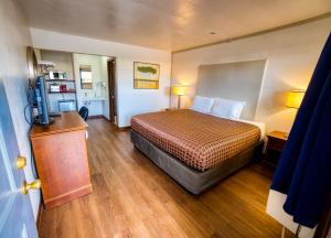 a hotel room with a bed and a television at Budget Inn in The Dalles