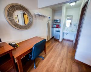 a room with a desk and a mirror on the wall at Budget Inn in The Dalles