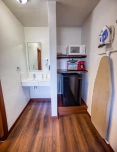 Habitación con TV, lavabo y espejo. en Budget Inn en The Dalles