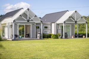 a white house with a lawn in front of it at 305 in the Vines in Havelock North