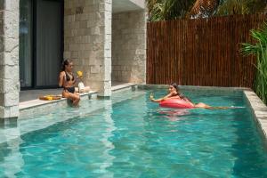 two women are in a swimming pool at Alea Tulum in Tulum