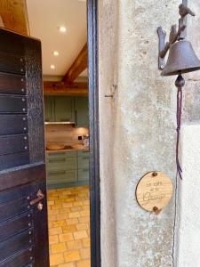 a door to a kitchen with a bell on the wall at Le Gîte de la Grange in La Wantzenau