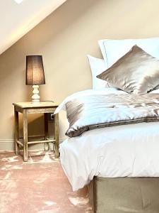 a bedroom with a bed and a table with a lamp at Le Gîte de la Grange in La Wantzenau