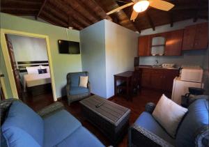 uma sala de estar com um sofá azul e uma cozinha em Eastern Harbor Resort em Útila