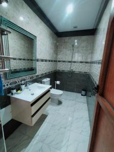 a bathroom with a toilet and a sink and a shower at Appartement de luxe à 7 min de Centre de ville in Marrakech