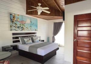 een slaapkamer met een bed en een plafondventilator bij Eastern Harbor Resort in Utila