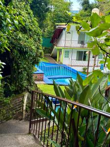 une maison avec une piscine et une clôture dans l'établissement BUNGALOWS ANDREA, à Tepoztlán