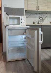 una nevera vacía en una cocina con microondas en Cosy Apartment, en Tauplitz