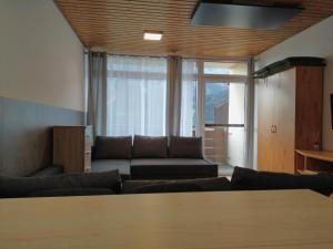 a living room with a couch and a large window at Cosy Apartment in Tauplitz