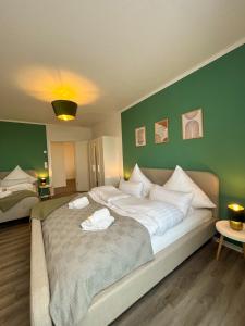 un grande letto in una stanza con parete verde di Home Inn Apartments - 202 a Minden