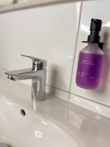 a bottle of purple soap sitting on a bathroom sink at Home Inn Apartments - 202 in Minden