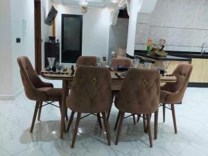 uma sala de jantar com uma mesa de madeira e cadeiras em Appartement de luxe à 7 min de Centre de ville em Marrakech