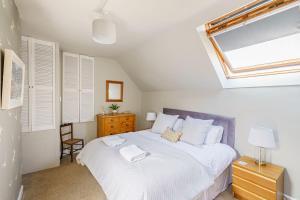 a bedroom with a bed with white sheets and a window at The Cheeseloft - Spacious one bed with terrace in Kirkcudbright